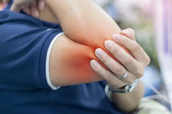 tennis elbow pain illustrated by a hand holding the elbow